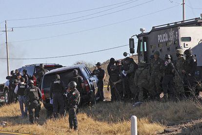 Policía federal de México custodian el vehículo oficial con el que viajaban los dos agentes cuando fueron atacados.