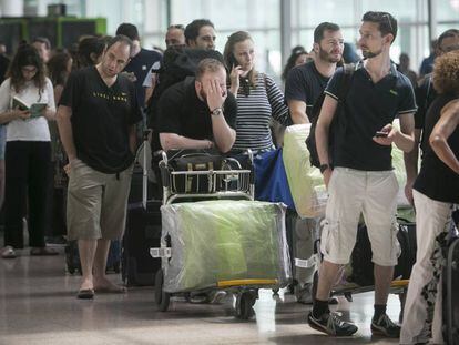 Colas de pasajeros de Vueling en El Prat (Barcelona), este domingo.