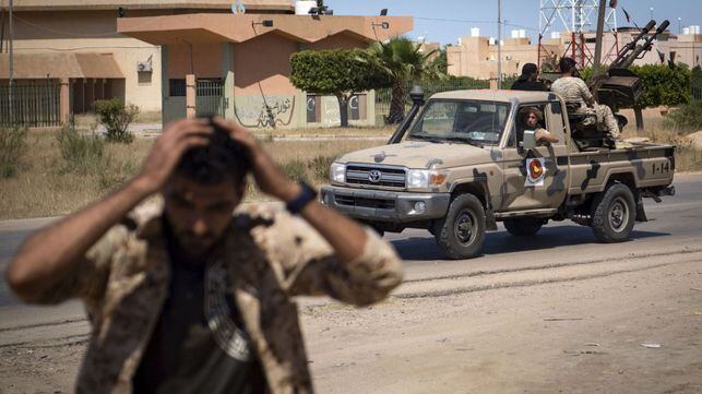 Un combatiente leal al Gobierno de Acuerdo Nacional (GNA) de Libia, reconocido internacionalmente, se tapa los oídos cuando otros soldados se preparan para disparar a unos 40 kilómetros al sur de la capital, Trípoli, el 29 de abril de 2019.
