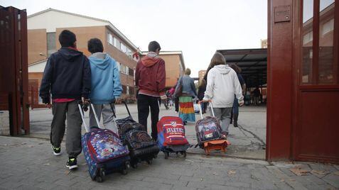 Varios niños entran en el colegio público La Latina en Aluche.