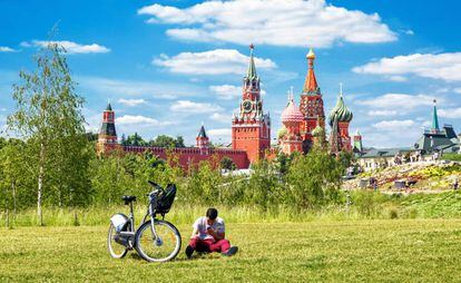 Un ciclista urbano descansando en el parque Zaryadye de Moscú, con el Kremlin y la catedral de San Basilio al fondo.
