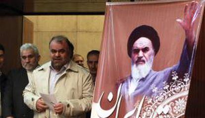 El ministro iraní de Petróleo, Rostam Qasemi, pasa junto a una fotografía del ayatolá Ruhola Jomeini antes de una rueda de prensa en Teherán (Irán). EFE/Archivo