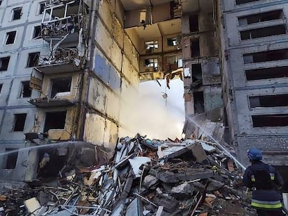 Los bomberos trabajan en el edificio de viviendas bombardeado este domingo en Zaporiyia, en una foto facilitada por los servicios de emergencias ucranios.