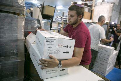Un empleat d'una fàbrica israeliana en territori ocupat amb una caixa de vi etiquetada com a 'Fet a Israel' aquest dilluns.