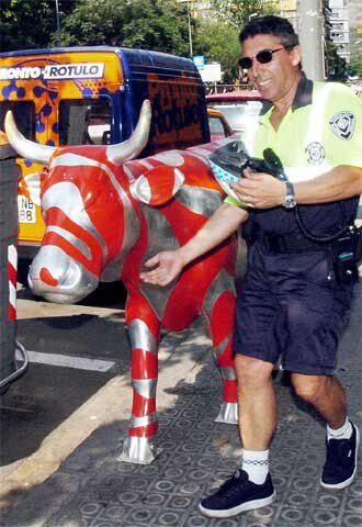 Un guardia urbano de Barcelona muestra la vaca que desapareció el pasado lunes.