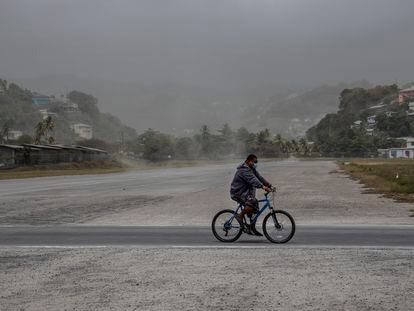 Un hombre se transporta en bicicleta por campos cubiertos de ceniza volcánica un día después de la erupción del volcán La Soufriere.