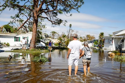 This Thursday, September 29, people walk through a neighborhood in Fort Myers (Florida), flooded by the passage of Hurricane 'Ian'.