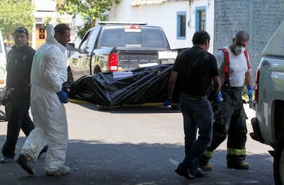 Personal forense traslada uno de los cadáveres en Guadalajara.