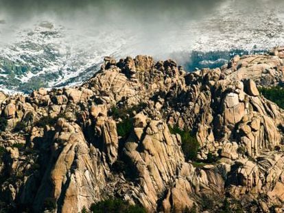 La belleza rocosa de la Cresta de las Milaneras, en La Pedriza posterior.  Al fondo, entre nubes, se divisa Cuerda Larga bajo la nieve.