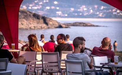 Un grupo de personas descansa en la terraza de un bar en el interior del festival.