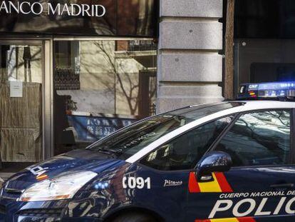 Un coche de polic&iacute;a aparcado frente a la oficina de Banco Madrid.