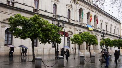 Varias personas caminan frente a la sede del ayuntamiento de Sevilla