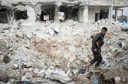 Un combatiente kurdo camina entre los escombros de un edificio en el centro de la ciudad siria de Kobane, este miércoles.
