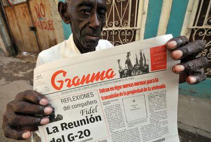 Un vendedor de periódicos muestra la edición de Granma de hoy que anuncia que Cuba pondrá en vigor a partir del 10 de noviembre nuevas normas que permitirán la compraventa de viviendas entre particulares tras décadas de prohibiciones.