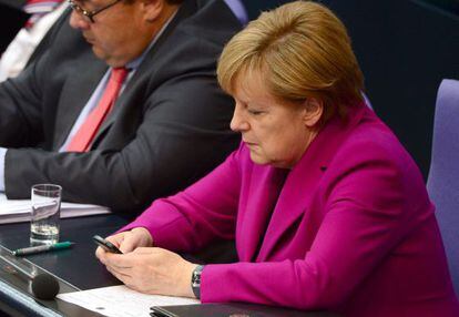 Angela Merkel consulta su tel&eacute;fono m&oacute;vil en el Bundestag, en junio de 2014. 
