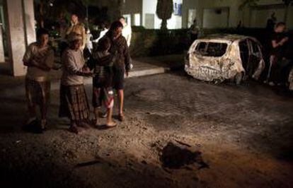 Residentes revisan el cr&aacute;ter dejado por un cohete  tras un ataque cerca a un complejo de apartamentos en Ashdod, Israel.