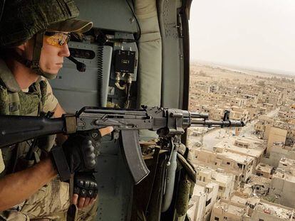 Un soldado ruso vigila desde un helic&oacute;ptero la ciudad siria de Palmira. 