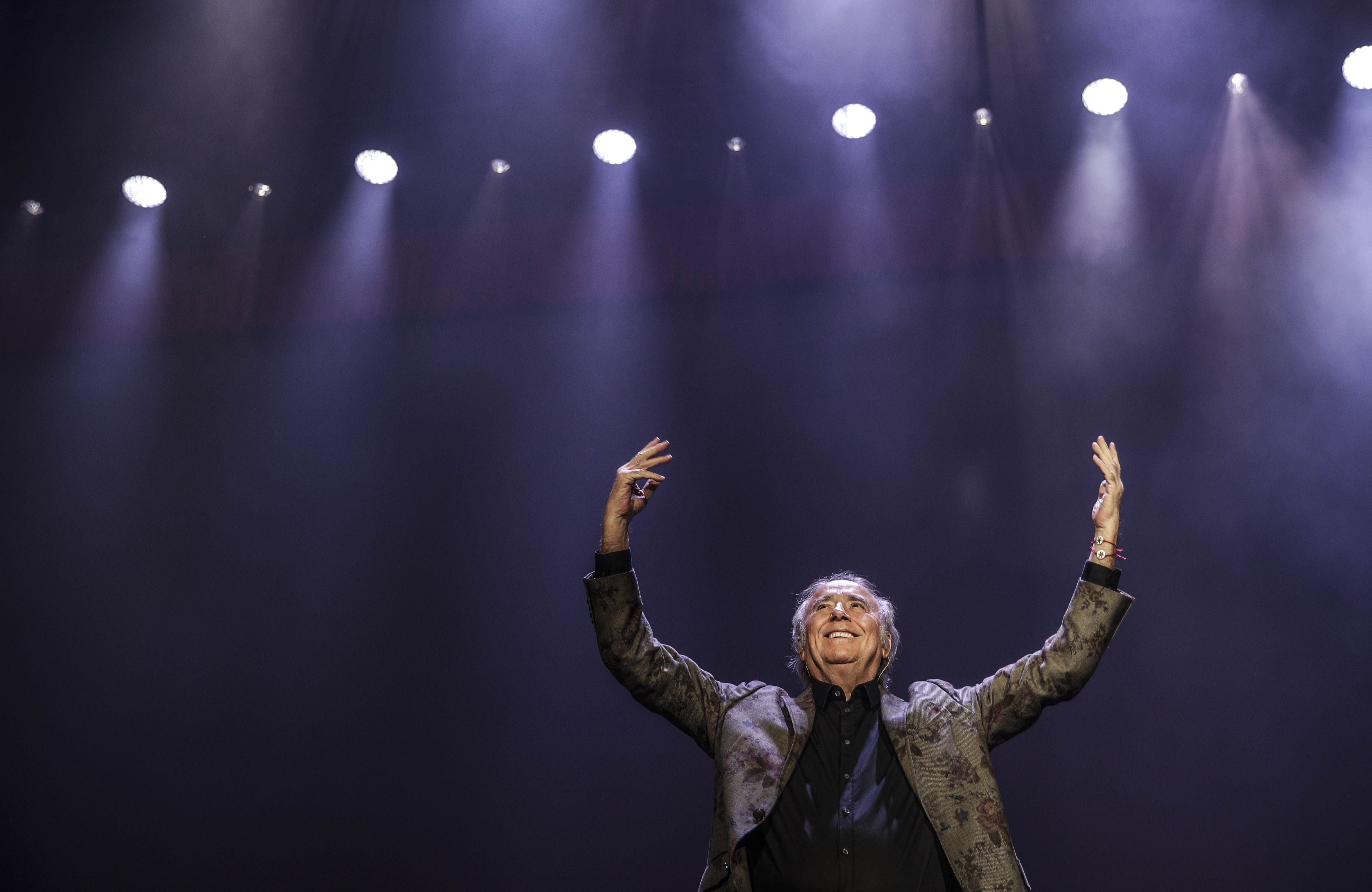 Joan Manuel Serrat alza los brazos al cielo en su concierto de despedida en el WiZink Center de Madrid.