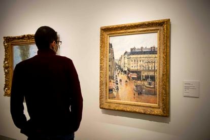 Un visitante observa el cuadro de Camille Pisarro, 'Rue Saint-Honoré por la tarde. Efecto de lluvia', esta mañana en el Thyssen.