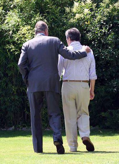 El rey Juan Carlos pasea con Adolfo Suárez, enfermo de alzheimer, por el jardín de su vivienda.