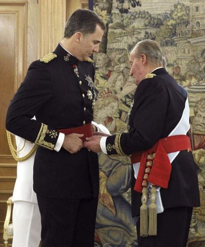 Don Juan Carlos coloca el fajín de capitán general de las Fuerzas Armadas a su hijo el rey Felipe VI en un acto breve y solemne celebrado en la sala de Audiencias del Palacio de la Zarzuela.
