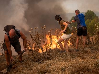 Vecinos colaboran en las labores de extinción en un incendio forestal, a 17 de julio de 2022, visto desde Sant Fruitós del Bages, Barcelona.