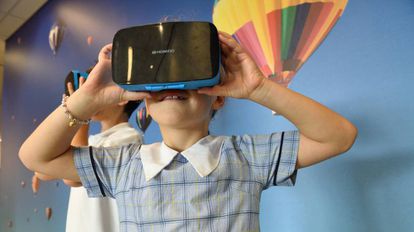 Una niña juega con un visor de realidad virtual.