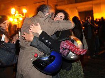 Dos italianos celebran la marcha de Berlusconi a las puertas del palacio presidencial, en Roma. 