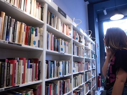 Una mujer revisa una estantería en una librería en Madrid.