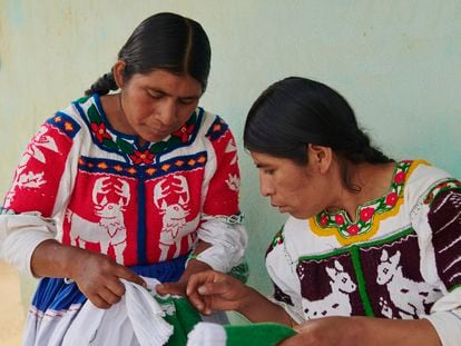 Las artesanas Irma Silva Vásquez y Marcelina Santiago González bordan una falda y una chaqueta blanca con la técnica del pepenado fruncido, típica de la región de San Lucas Redención, en Oaxaca, México.