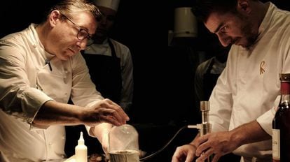 Joan Roca y, a la derecha, su hermano Jordi preparan un plato con madera.