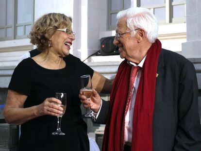 La alcaldesa de Madrid, Manuela Carmena, brinda con el presidente de la Fundación Mensajeros de la Paz, el padre Ángel, en la Galería de Cristal del Ayuntamiento de Madrid.