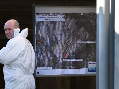Un polic&iacute;a ante un mapa topogr&aacute;fico del lugar del siniestro de Germanwings. 