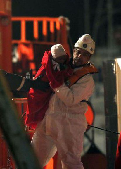 Un miembro de los equipos de emergencias traslada al bebé rescatado esta madrugada en el Mediterráneo.