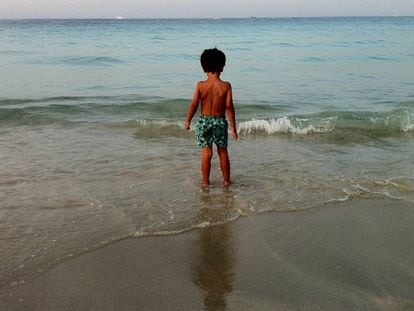 Un nen a punt de banyar-se en una platja.