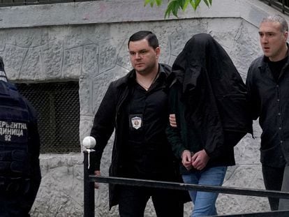 Agentes de policía escoltan al menor sospechoso de matar a tiros a ocho alumnos y un vigilante en un colegio de Belgrado.