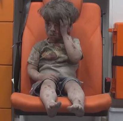 Omran, un niño de cinco años, sentado en una ambulancia tras ser rescatado de una vivienda bombardeada en Alepo.