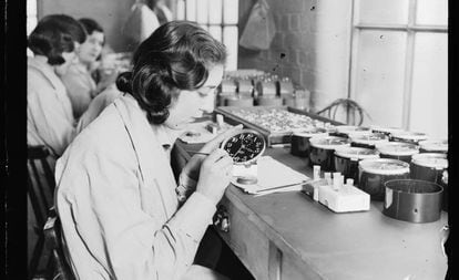 Una trabajadora emplea pintura luminosa en una fábrica de relojes en 1932.
