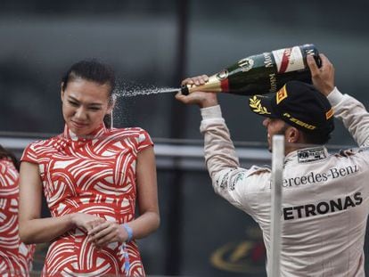 Lewis Hamilton celebra su triunfo en Shanghái rociando de champán a una azafata china.