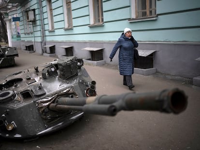 Una mujer camina junto a varios tanques rusos destruidos y expuestos en una calle de Kiev, este miércoles.
