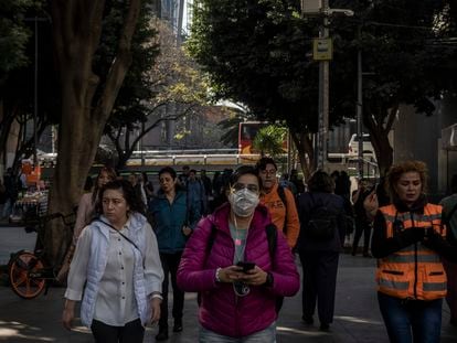 Una mujer camina con un cubre bocas en Ciudad de México este viernes.