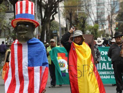 Seguidores del presidente de Bolivia, Evo Morales, protestan cubiertos con banderas ante la embajada de EE UU en La Paz (Bolivia).