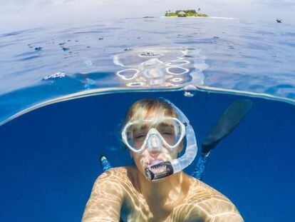 Una mujer se sumerge debajo del agua del mar mediante la técnica del 'snorkel'.