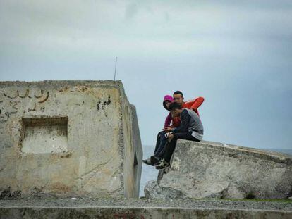 Tres menores sentados frente al mar en Ceuta, el pasado viernes.