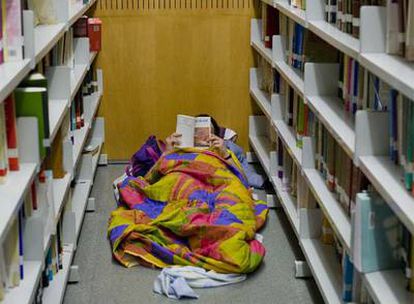 Uno de los estudiantes encerrados en la UPF lee echado en el suelo de la biblioteca.