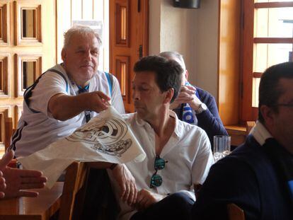 Ricardo Heyroth, 'El Alemán', como lo llaman en el pueblo de Los Molinos, bromea con un banderín del Real Madrid con uno de sus amigos del bar Los Ángeles, donde se juntan a ver los partidos del club merengue.