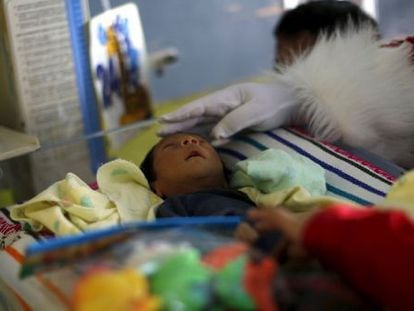 Un hombre vestido como Santa Claus acaricia a un beb&eacute; en un hospital guatemalteco el pasado 16 de diciembre.