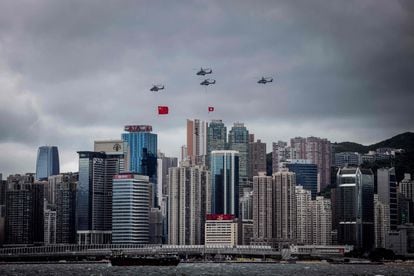Varios helicópteros vuelan con las banderas de Hong Kong y China, durante una ceremonia para celebrar el 25º aniversario del traspaso de la ciudad de Gran Bretaña a China.