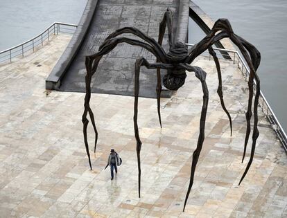 Una persona camina bajo la escultura de Louise Bourgeois 'Mamá', en las inmediaciones del Museo Guggenheim de Bilbao, el 27 de abril.