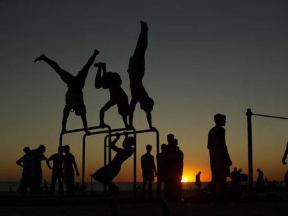 Varios ciudadanos hacen gimnasia en la playa de la Victoria de Cádiz este lunes.